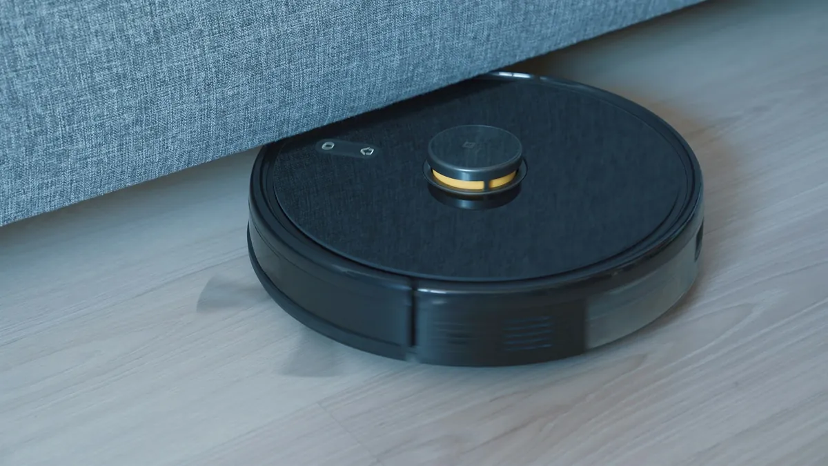 Robot hút bụi màu đen trên sàn gỗ