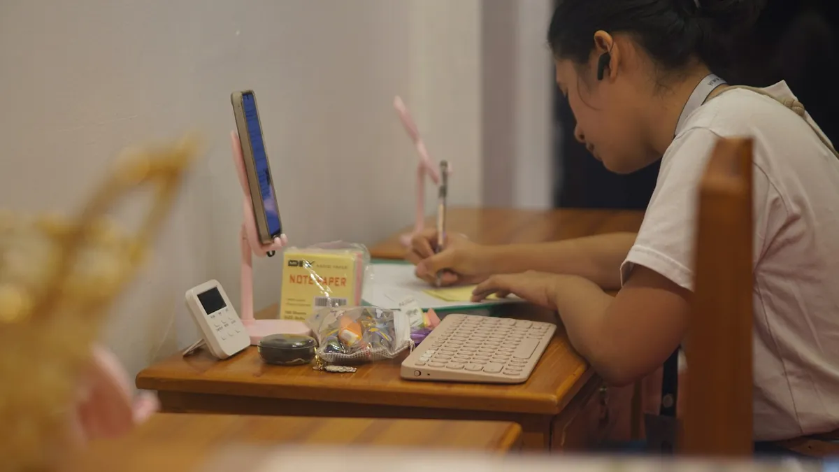 Học sinh làm bài bên bàn học