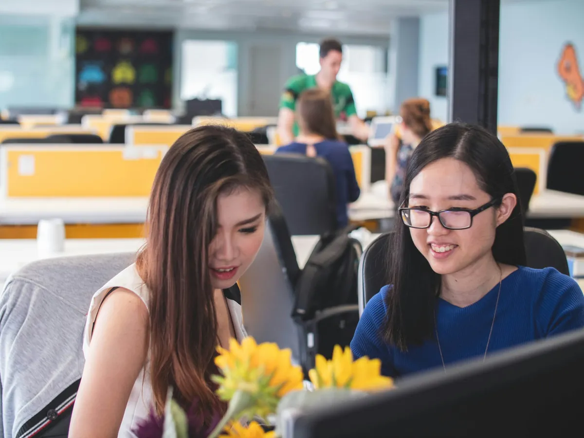 Hai học viên cười trước màn hình máy tính
