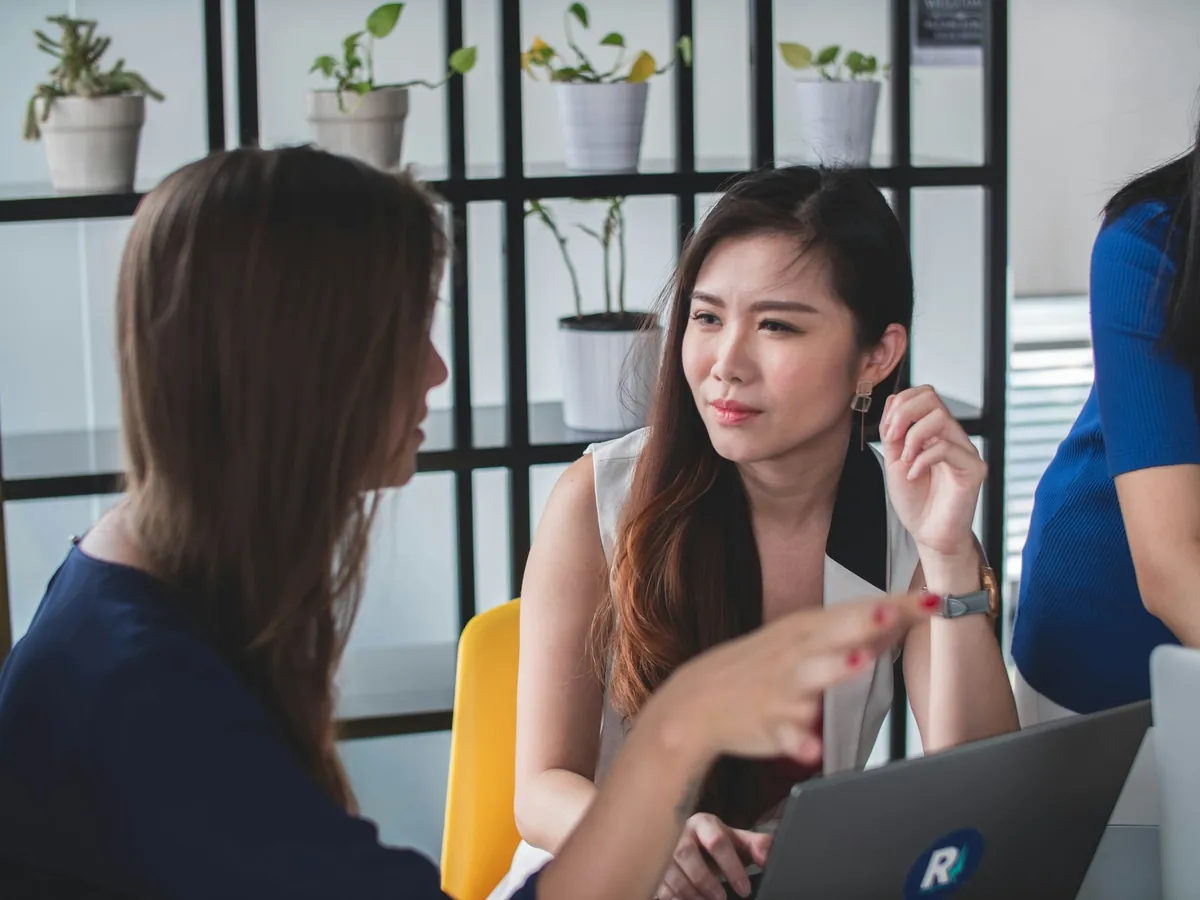 Hai chuyên viên trao đổi công việc bên laptop